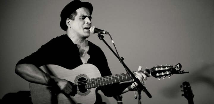Photo d'Erick Manana en train de chanter en jouant de la guitare